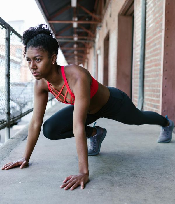 Woman in activewear performing a calm cardio movement indoors.